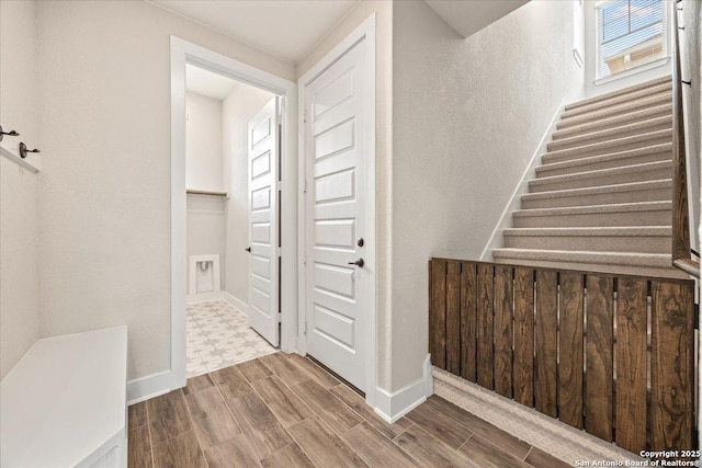 staircase with baseboards and wood tiled floor