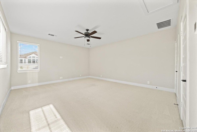 spare room with visible vents, baseboards, and light carpet