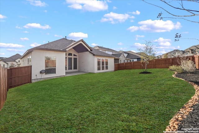 back of house featuring a yard, a fenced backyard, and stucco siding