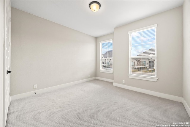 carpeted spare room with baseboards