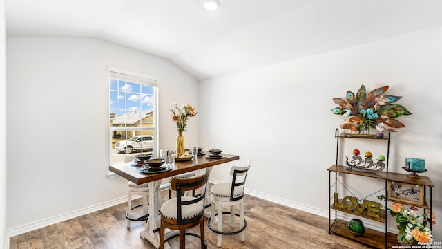 dining room with lofted ceiling, wood finished floors, and baseboards