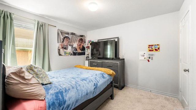 bedroom with light colored carpet and baseboards