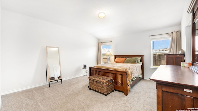 bedroom featuring baseboards, light carpet, and vaulted ceiling