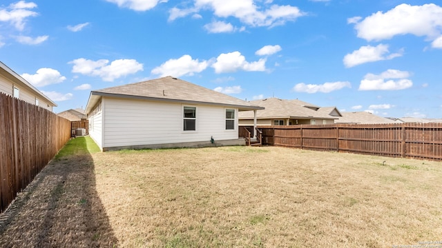 back of house with a lawn and a fenced backyard