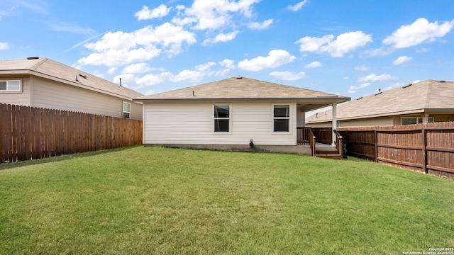 back of property featuring a lawn and a fenced backyard