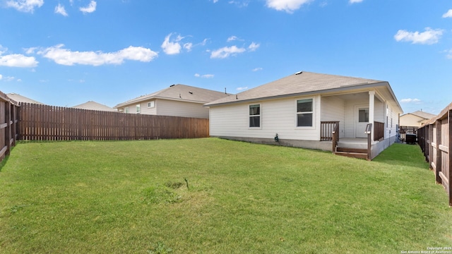 rear view of property with a lawn and a fenced backyard