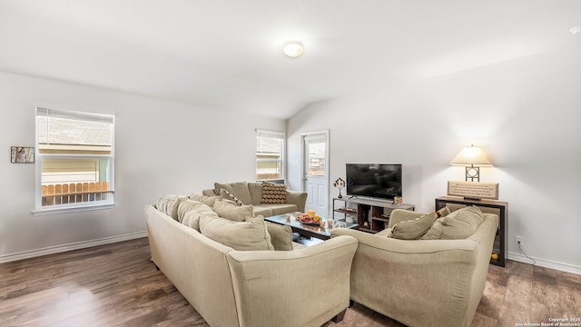 living room with baseboards, lofted ceiling, and wood finished floors