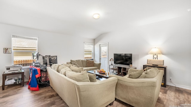 living area featuring vaulted ceiling, wood finished floors, and baseboards