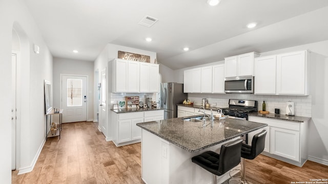 kitchen featuring light wood-type flooring, visible vents, a sink, white cabinetry, and stainless steel appliances