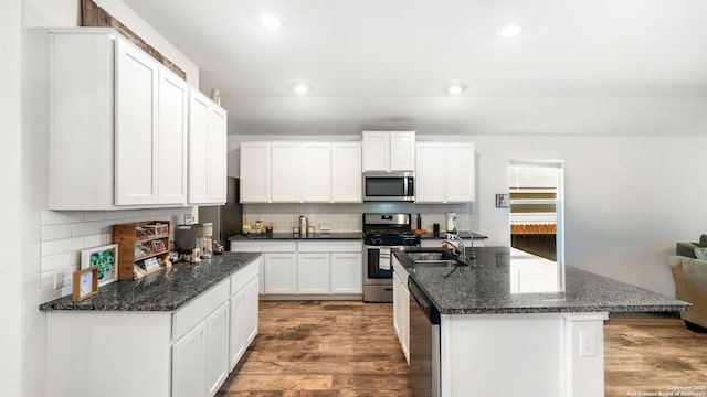 kitchen featuring backsplash, wood finished floors, white cabinetry, recessed lighting, and stainless steel appliances