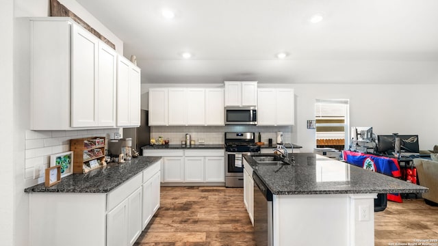 kitchen featuring light wood-style flooring, tasteful backsplash, recessed lighting, stainless steel appliances, and white cabinets