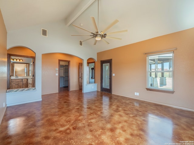 interior space with visible vents, a ceiling fan, finished concrete floors, arched walkways, and baseboards