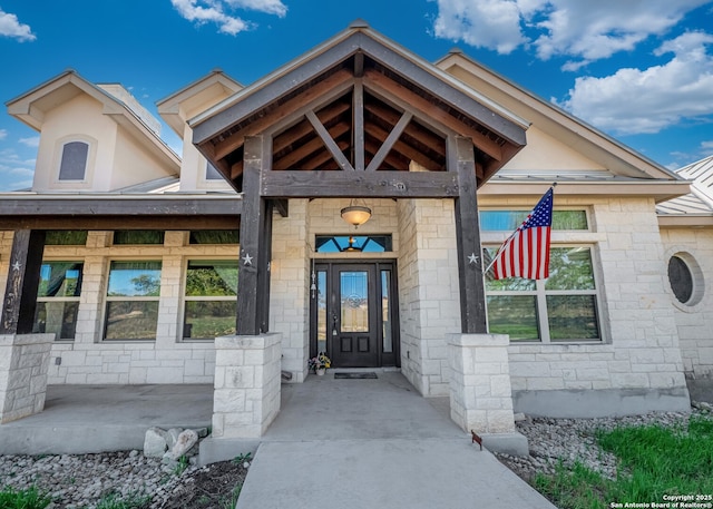 doorway to property featuring covered porch and stone siding