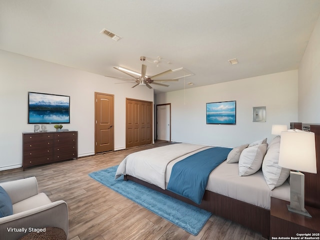 bedroom featuring visible vents, attic access, a ceiling fan, and wood finished floors