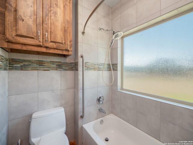 bathroom with toilet, tile walls, and shower / bathtub combination