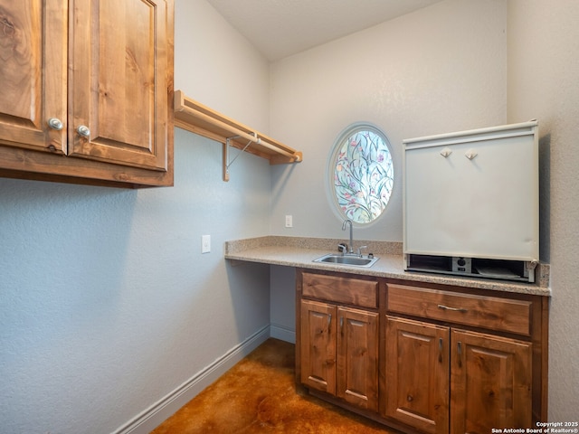 laundry area featuring a sink and baseboards