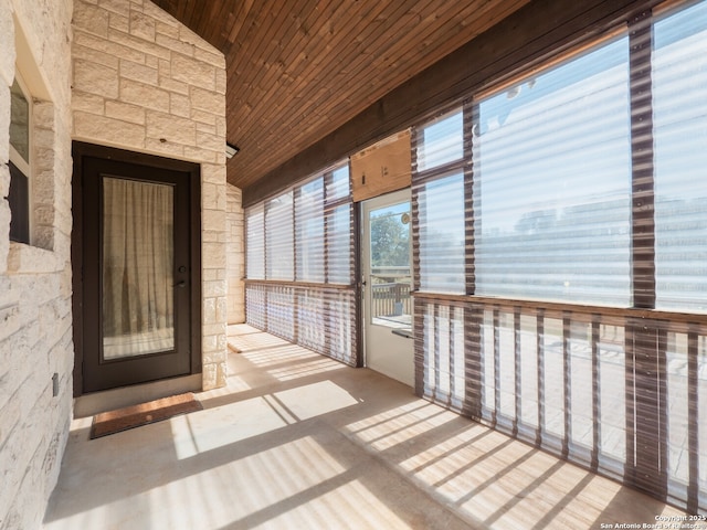 unfurnished sunroom with wooden ceiling and vaulted ceiling