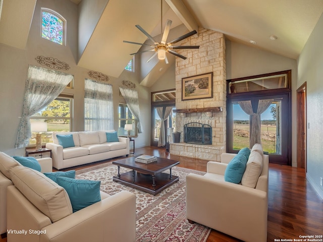 living area featuring plenty of natural light, a fireplace, wood finished floors, and a ceiling fan