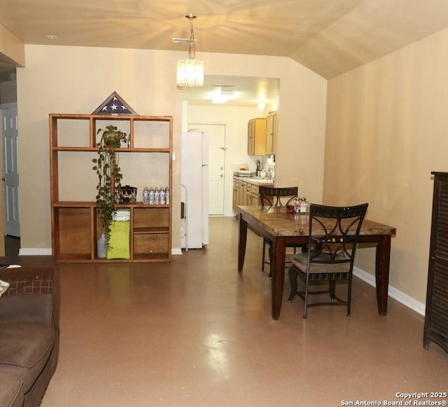 dining area featuring vaulted ceiling and baseboards