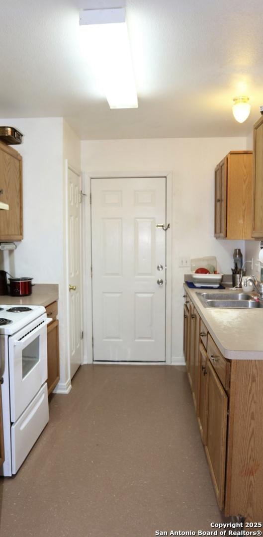 kitchen featuring light countertops, electric range, and a sink