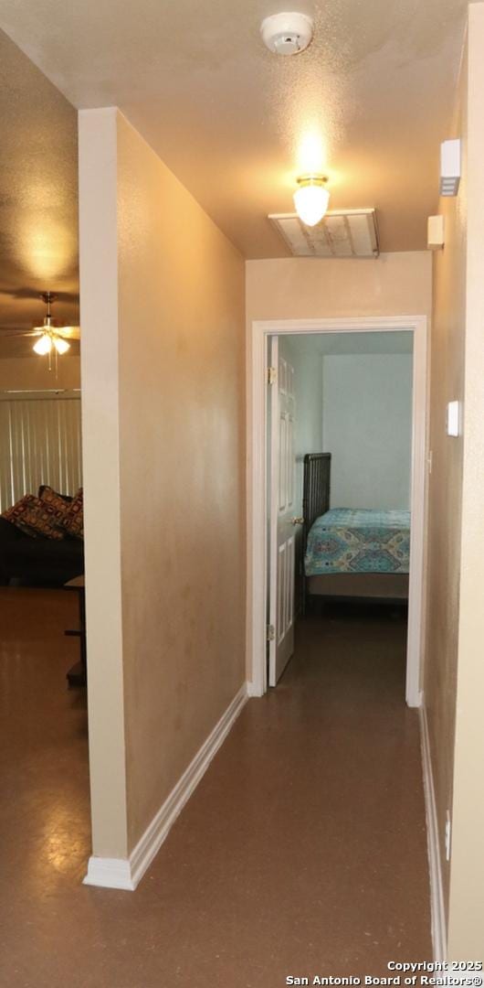 hallway with baseboards and visible vents