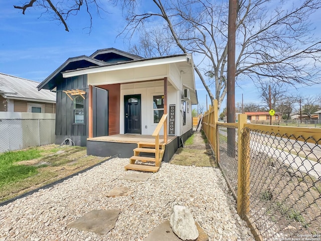 bungalow-style house featuring board and batten siding, a fenced backyard, and covered porch