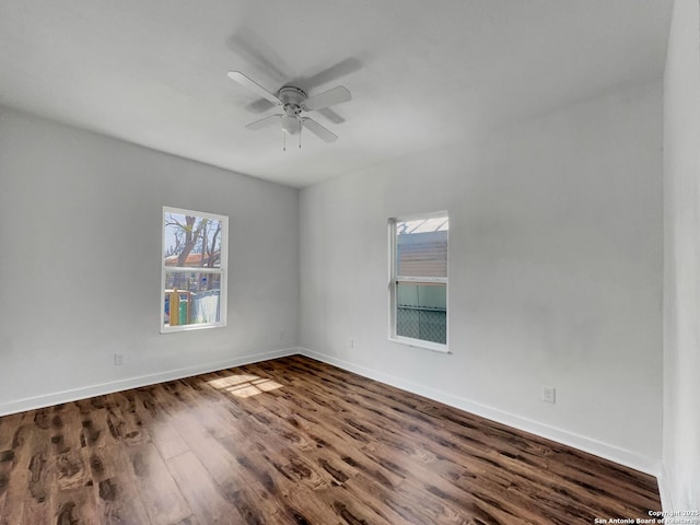 empty room with baseboards, ceiling fan, and wood finished floors