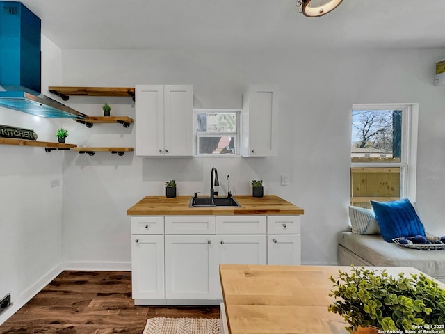 kitchen featuring a sink, dark wood finished floors, butcher block countertops, white cabinetry, and open shelves