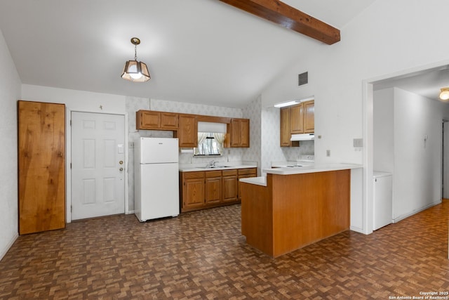 kitchen with visible vents, a sink, lofted ceiling with beams, freestanding refrigerator, and a peninsula