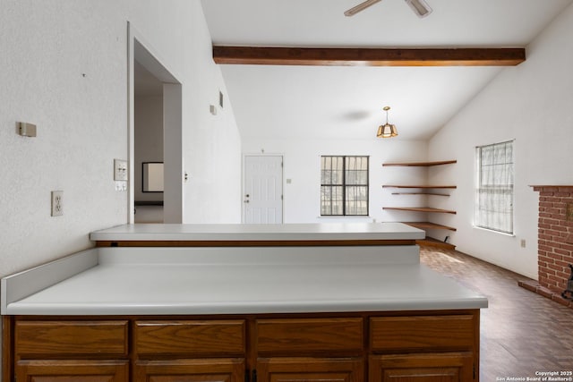 kitchen with lofted ceiling with beams, brown cabinets, a peninsula, and light countertops