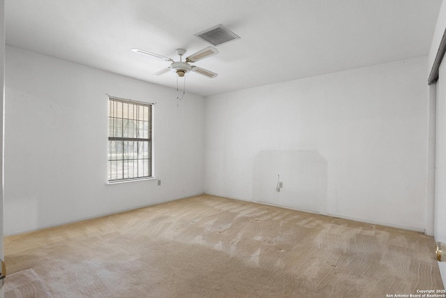 carpeted empty room featuring visible vents and ceiling fan