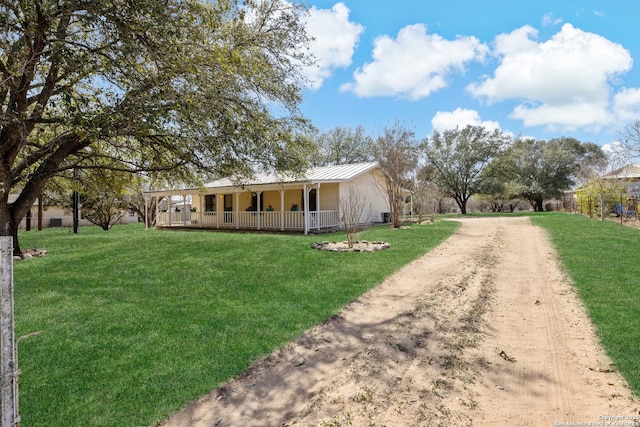 ranch-style house featuring a porch, a front yard, driveway, and metal roof