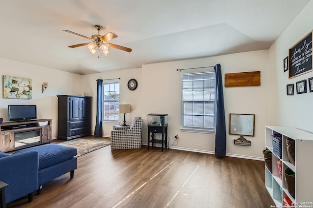 living area featuring baseboards, a ceiling fan, and wood finished floors