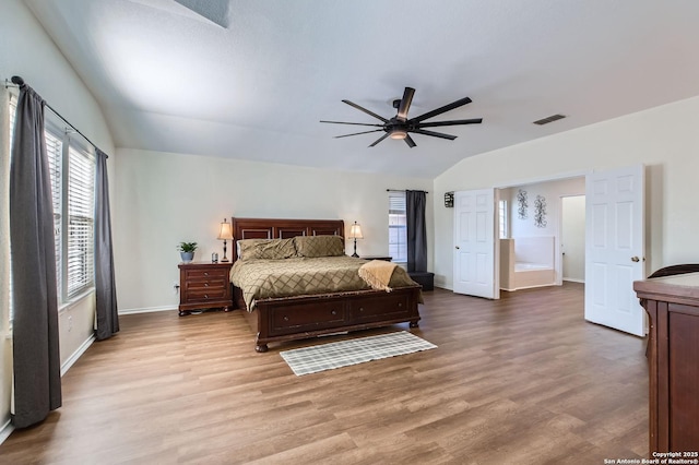 bedroom featuring visible vents, a ceiling fan, wood finished floors, baseboards, and vaulted ceiling