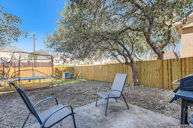 view of patio / terrace featuring a fenced backyard, grilling area, and a trampoline