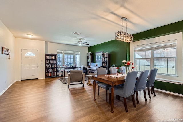 dining area with visible vents, a ceiling fan, baseboards, and wood finished floors