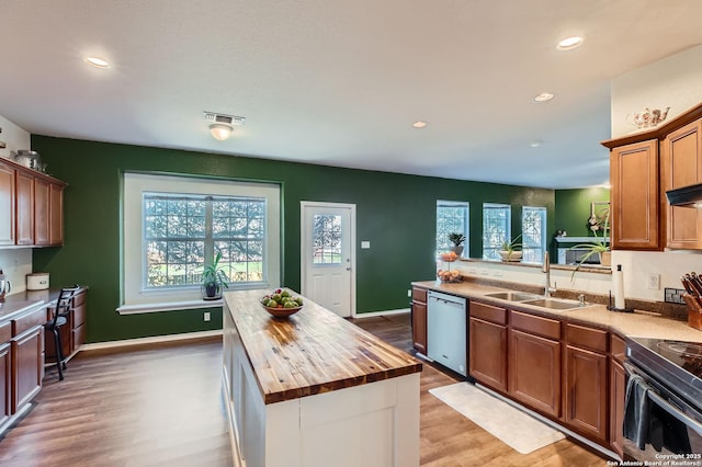 kitchen featuring visible vents, butcher block countertops, a sink, stainless steel dishwasher, and electric range oven