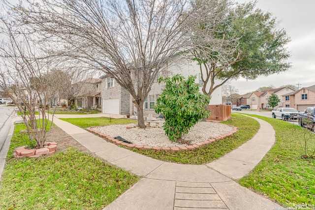 view of property's community featuring a yard, a residential view, and driveway