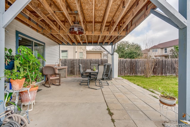 view of patio featuring outdoor dining area and fence