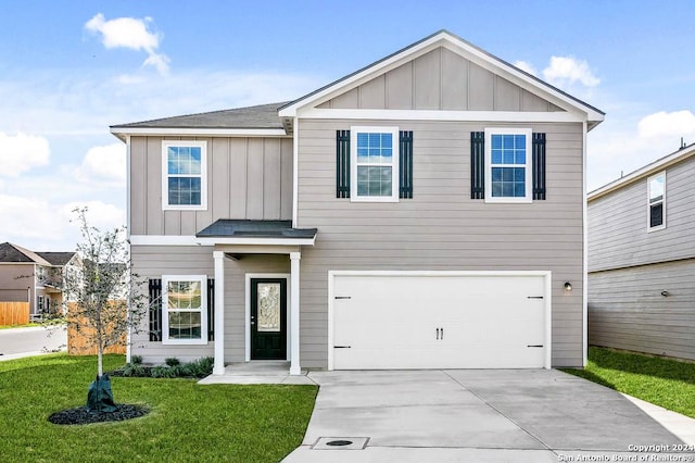 view of front of house with board and batten siding, a front lawn, driveway, and a garage