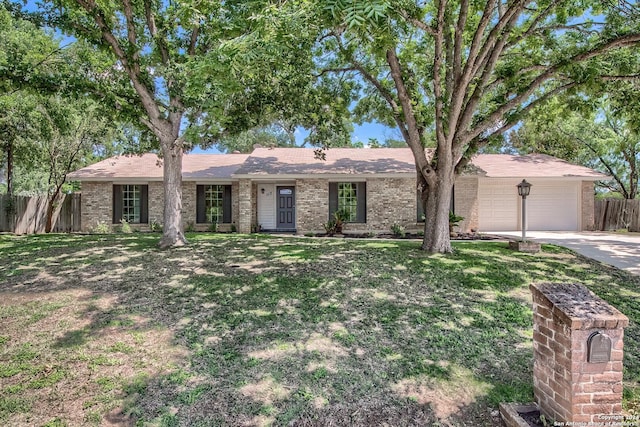 single story home with brick siding, a front lawn, fence, driveway, and an attached garage