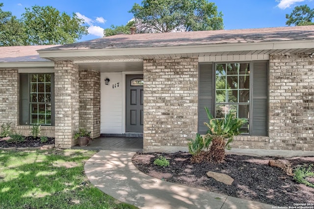 view of exterior entry with brick siding