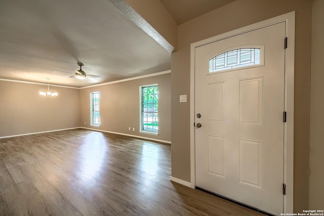 foyer featuring baseboards, ornamental molding, dark wood-style flooring, and ceiling fan with notable chandelier