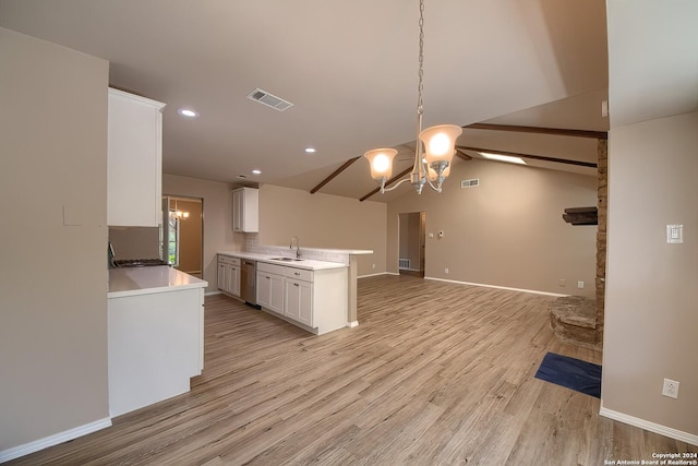 kitchen featuring visible vents, a sink, open floor plan, white cabinets, and a chandelier