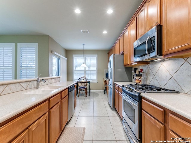 kitchen featuring a sink, visible vents, appliances with stainless steel finishes, and brown cabinetry