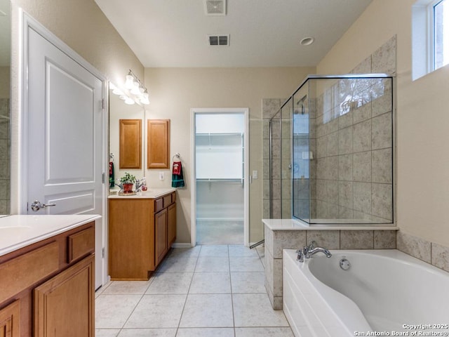 full bathroom featuring visible vents, two vanities, a shower stall, and tile patterned flooring