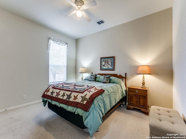 bedroom with visible vents, baseboards, light colored carpet, and a ceiling fan