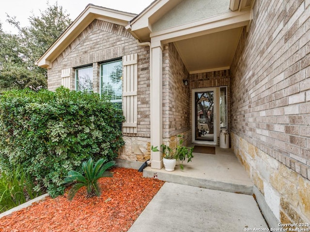 entrance to property with brick siding and stone siding