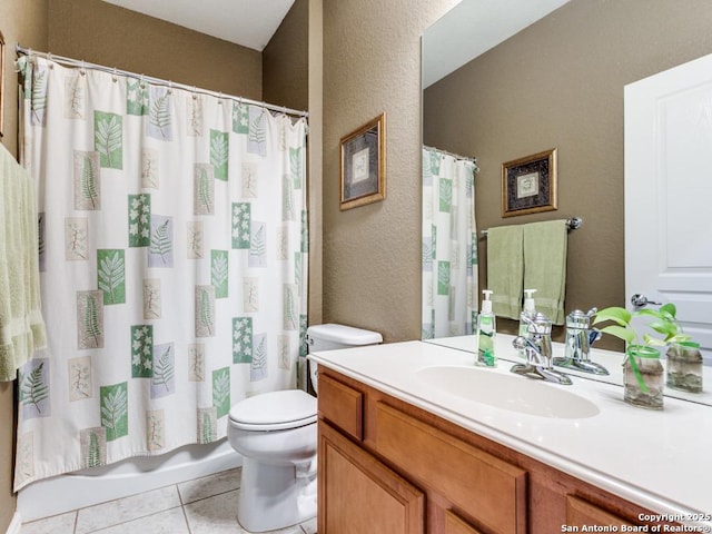 bathroom featuring tile patterned flooring, toilet, vanity, and a textured wall