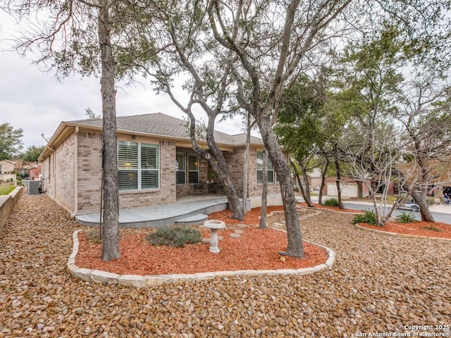 rear view of house featuring brick siding, central AC, and a patio area